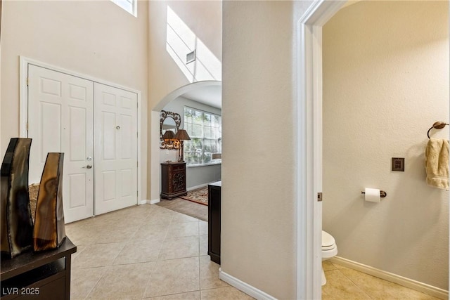 248 Hyssop Ct, Henderson, NV 89015 - foyer with light tile patterned floors, arched walkways, baseboards, and a towering ceiling