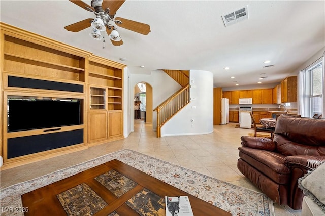 248 Hyssop Ct, Henderson, NV 89015 - living room with visible vents, stairs, baseboards, arched walkways, and light tile patterned floors