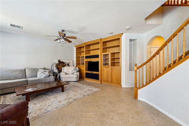 248 Hyssop Ct, Henderson, NV 89015 - living room featuring ceiling fan, visible vents, light tile patterned floors, and stairway