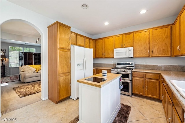 248 Hyssop Ct, Henderson, NV 89015 - kitchen with brown cabinets, light tile patterned flooring, white appliances, arched walkways, and light countertops