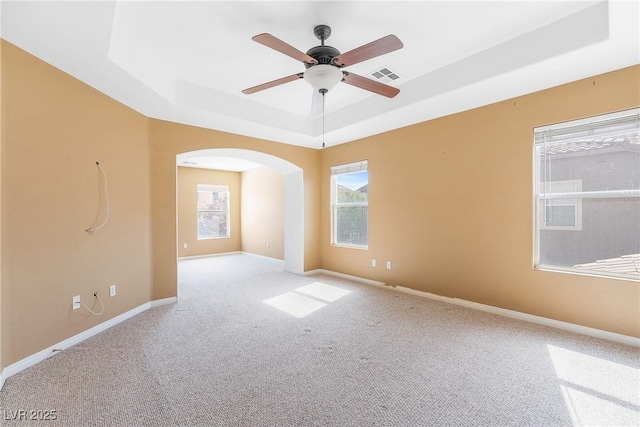 248 Hyssop Ct, Henderson, NV 89015 - carpeted empty room with visible vents, baseboards, ceiling fan, a raised ceiling, and arched walkways