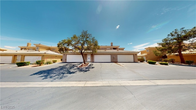 6901 Cobre Azul Ave Unit 202, Las Vegas, NV 89108 - view of front of property with stucco siding, a tile roof, and driveway
