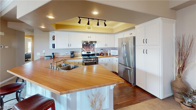 6901 Cobre Azul Ave Unit 202, Las Vegas, NV 89108 - kitchen with appliances with stainless steel finishes, a sink, ornamental molding, a peninsula, and under cabinet range hood