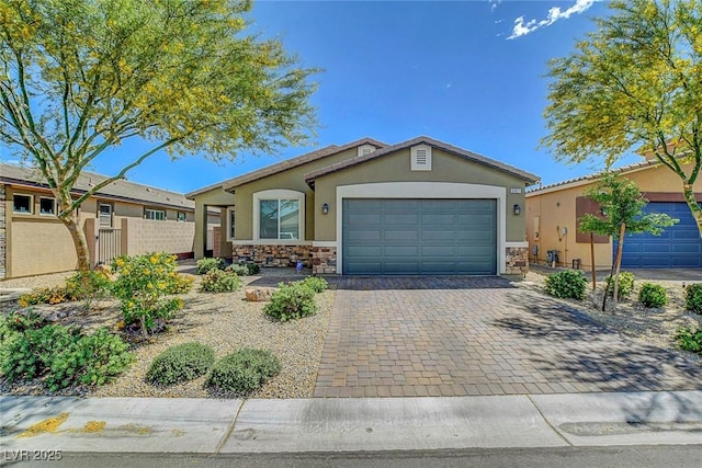 single story home with fence, an attached garage, stone siding, stucco siding, and decorative driveway