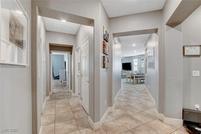 hallway with baseboards and light tile patterned floors