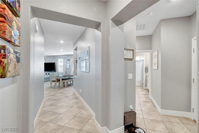 hallway featuring recessed lighting, baseboards, visible vents, and light tile patterned floors