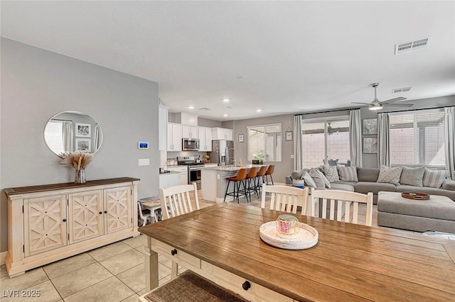 dining space with light tile patterned flooring, a ceiling fan, visible vents, and recessed lighting