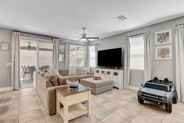 living room featuring visible vents, a ceiling fan, baseboards, and light tile patterned floors