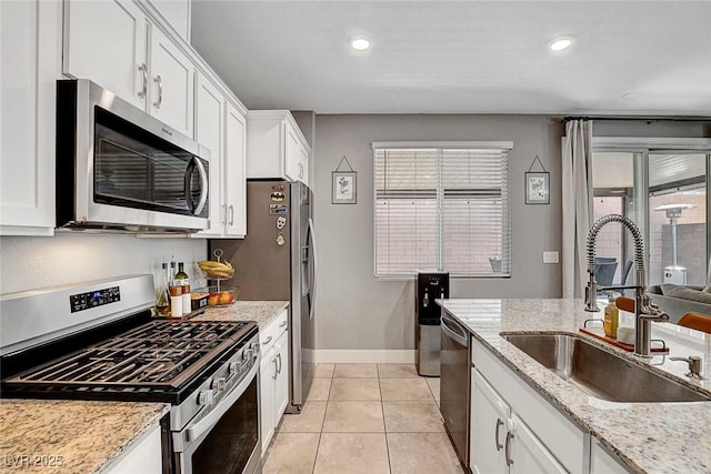kitchen with a sink, white cabinetry, appliances with stainless steel finishes, and a healthy amount of sunlight