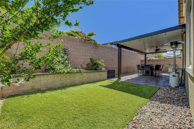 view of yard featuring ceiling fan, a fenced backyard, and a patio area