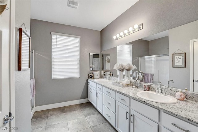 full bathroom featuring a sink, baseboards, a shower stall, and tile patterned floors