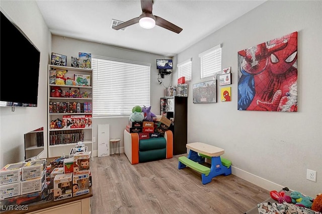 recreation room with ceiling fan, a healthy amount of sunlight, and wood finished floors