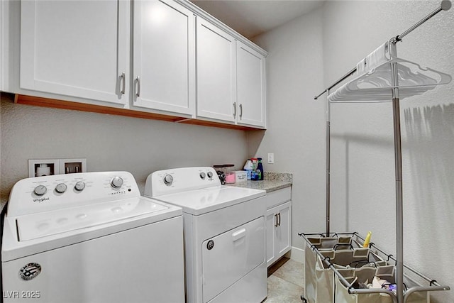 laundry area with cabinet space, light tile patterned floors, and washing machine and clothes dryer
