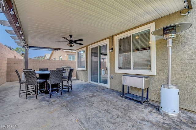 view of patio with ceiling fan, fence, and outdoor dining area