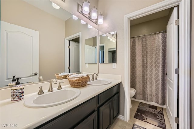 full bathroom featuring double vanity, a sink, tile patterned floors, and toilet