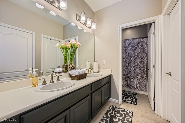 full bathroom featuring double vanity, tile patterned floors, and a sink