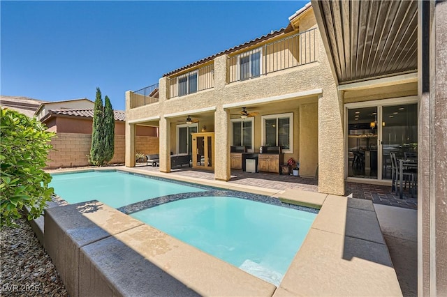 back of property with a ceiling fan, a balcony, an outdoor hangout area, stucco siding, and a tile roof