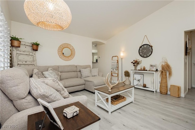 504 Painted Cloud Pl, Las Vegas, NV 89144 - living area with arched walkways, light wood-style flooring, a chandelier, and baseboards