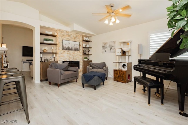 504 Painted Cloud Pl, Las Vegas, NV 89144 - sitting room featuring vaulted ceiling, light wood finished floors, built in features, a ceiling fan, and a fireplace