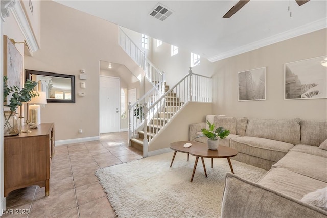living area with visible vents, stairs, baseboards, a ceiling fan, and light tile patterned floors
