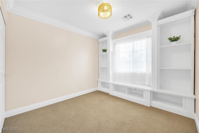 carpeted empty room with crown molding, baseboards, and visible vents