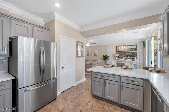 kitchen featuring gray cabinetry, light countertops, freestanding refrigerator, a peninsula, and open floor plan