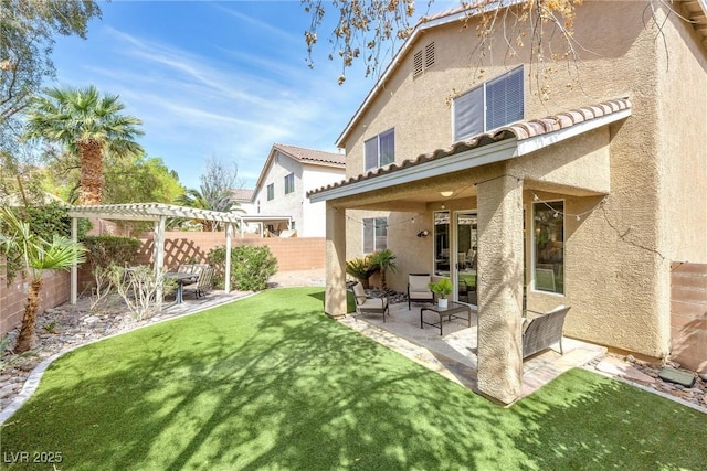 rear view of property featuring a fenced backyard, a pergola, stucco siding, and a lawn