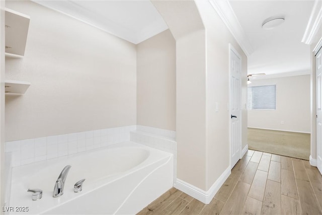 bathroom featuring baseboards, a garden tub, and wood finished floors