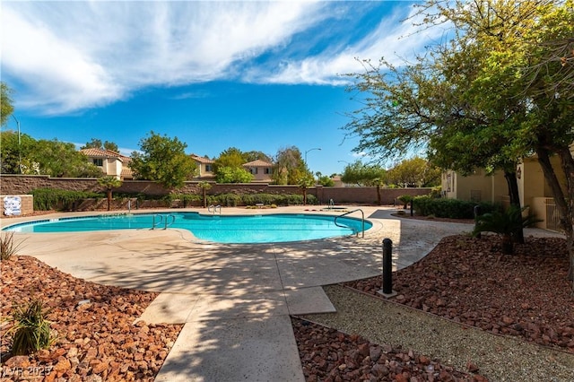 community pool featuring a patio and fence