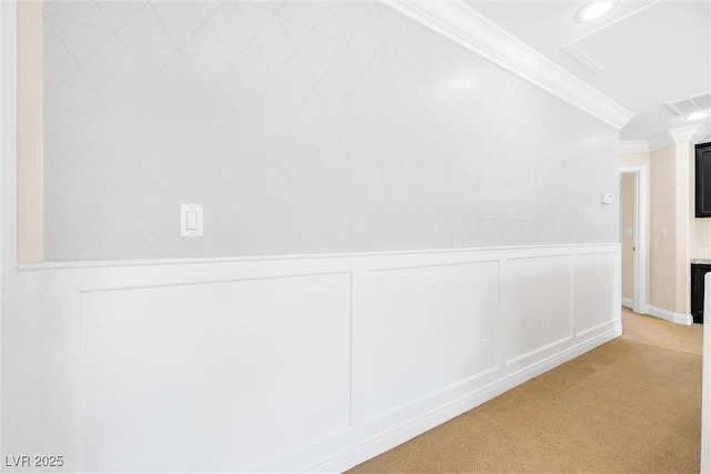 hallway with light colored carpet, ornamental molding, a decorative wall, and visible vents