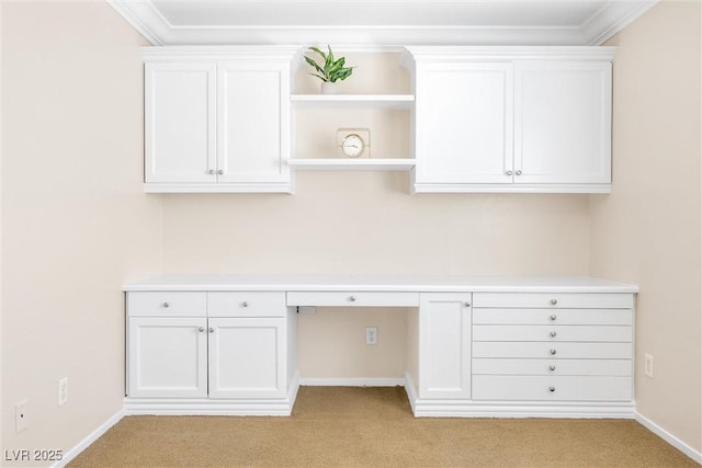 unfurnished office with built in study area, baseboards, and light colored carpet