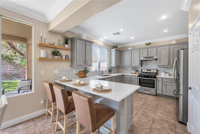 kitchen featuring visible vents, gray cabinets, under cabinet range hood, and stainless steel appliances