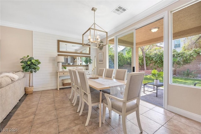dining room featuring a healthy amount of sunlight, ornamental molding, an inviting chandelier, and visible vents