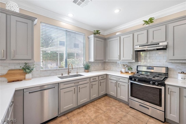 kitchen featuring under cabinet range hood, stainless steel appliances, a sink, and gray cabinets