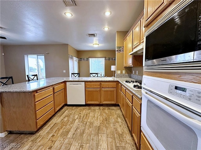 5704 Burdel St, Las Vegas, NV 89149 - kitchen featuring visible vents, a sink, light wood-style flooring, and white appliances