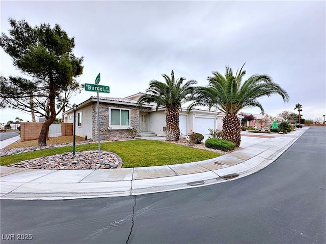 5704 Burdel St, Las Vegas, NV 89149 - ranch-style house featuring a front lawn, fence, stone siding, stucco siding, and an attached garage