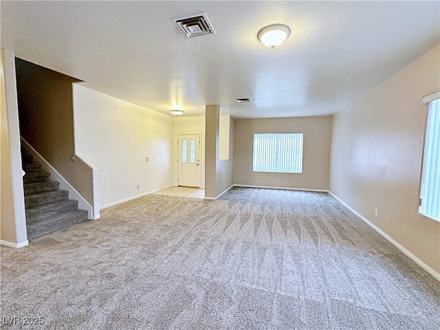 5704 Burdel St, Las Vegas, NV 89149 - unfurnished living room with visible vents, stairs, baseboards, and light colored carpet