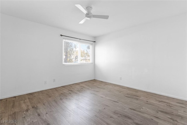 unfurnished room featuring a ceiling fan, baseboards, and wood finished floors