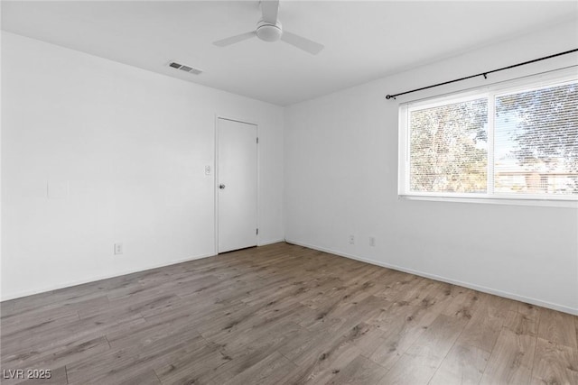unfurnished room featuring visible vents, baseboards, ceiling fan, and wood finished floors