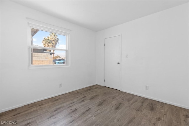 empty room featuring baseboards and wood finished floors