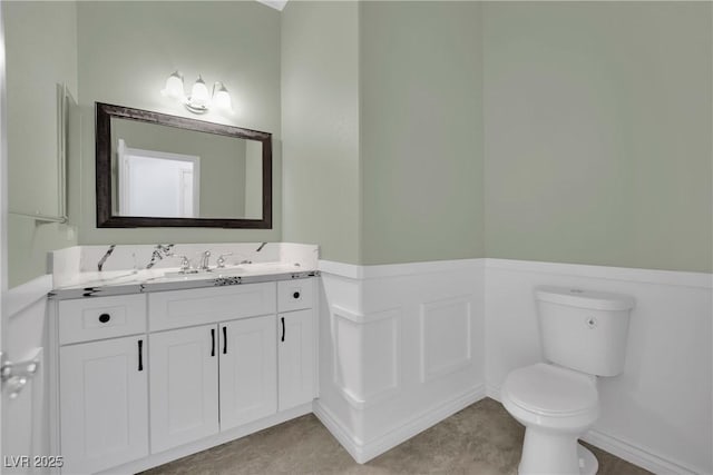 bathroom with vanity, baseboards, and toilet