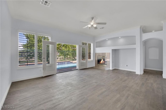 unfurnished living room featuring baseboards, ceiling fan, wood finished floors, and visible vents