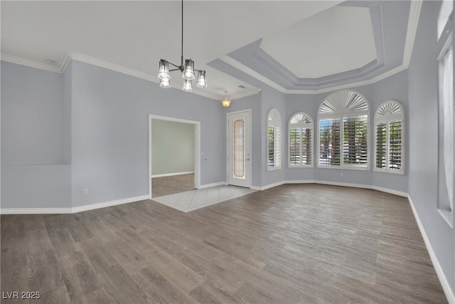interior space with crown molding, baseboards, wood finished floors, and a chandelier