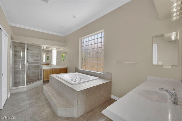 bathroom with a garden tub, crown molding, a shower stall, two vanities, and a sink