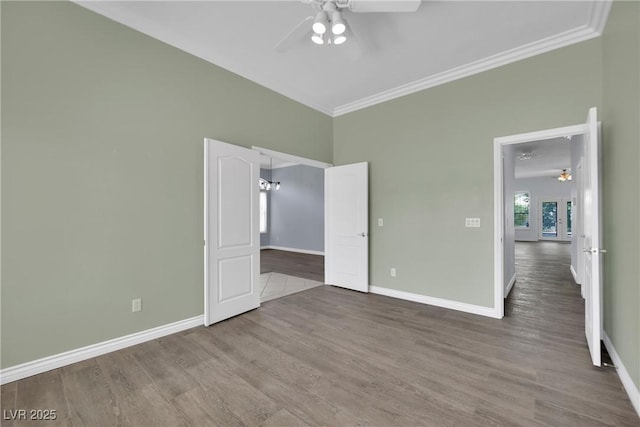 unfurnished bedroom featuring crown molding, baseboards, ceiling fan, and wood finished floors