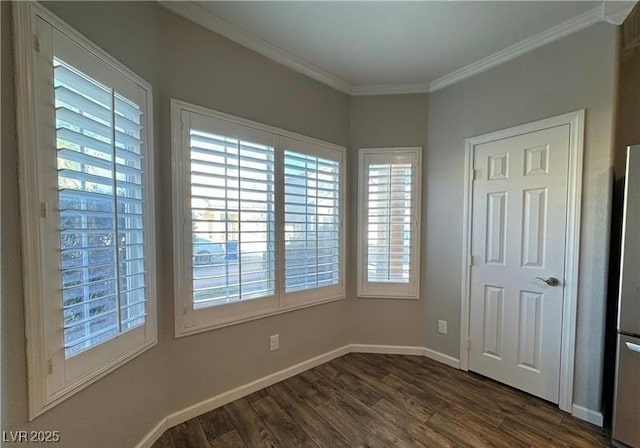 unfurnished room featuring dark wood finished floors, ornamental molding, and baseboards
