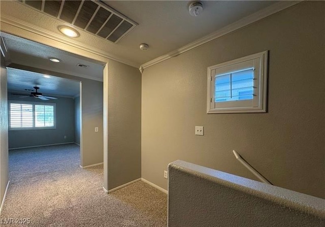 hallway with ornamental molding, carpet floors, and baseboards