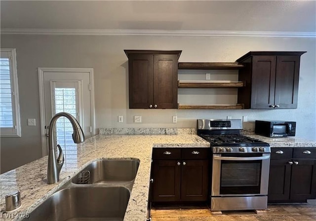 kitchen featuring stainless steel gas stove, a sink, open shelves, black microwave, and dark brown cabinets