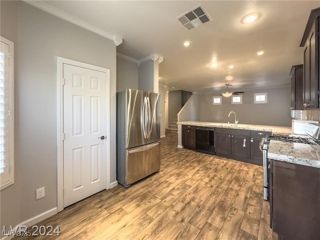 kitchen with appliances with stainless steel finishes, crown molding, light wood-style floors, ceiling fan, and dark brown cabinets