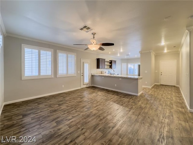 unfurnished living room with crown molding, dark wood-type flooring, a ceiling fan, baseboards, and a sink
